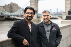 Two men wearing Physician MBA Program attire stand on a bridge in London.